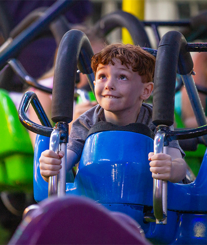 A boy enjoying a Fair ride.
